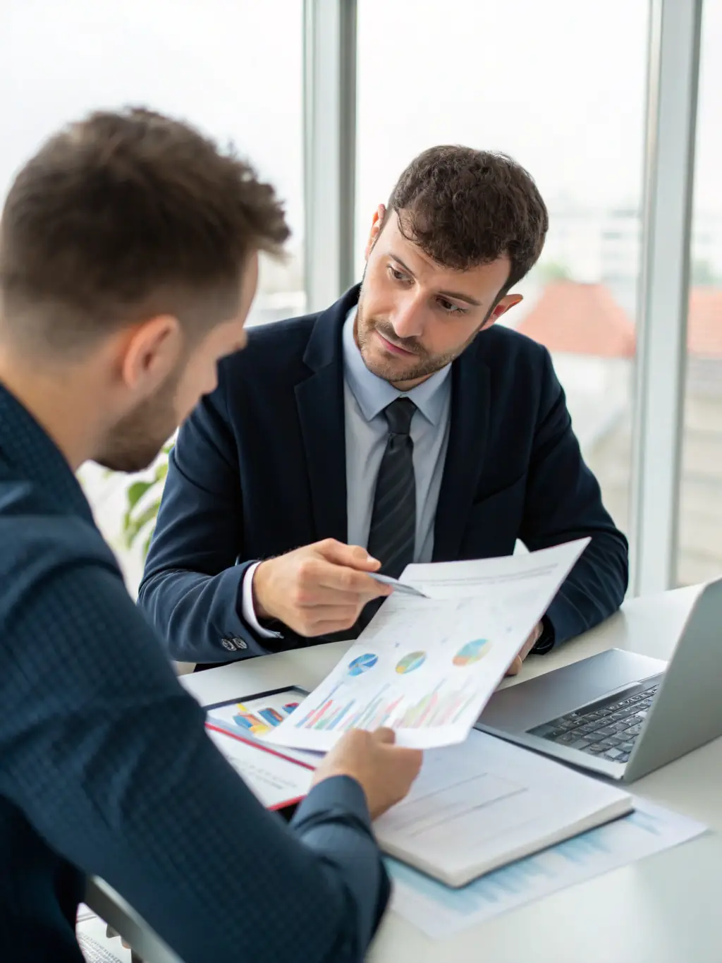 An image of a professional accountant reviewing financial documents with a client in a modern office setting, symbolizing IE Financials' accounting services.